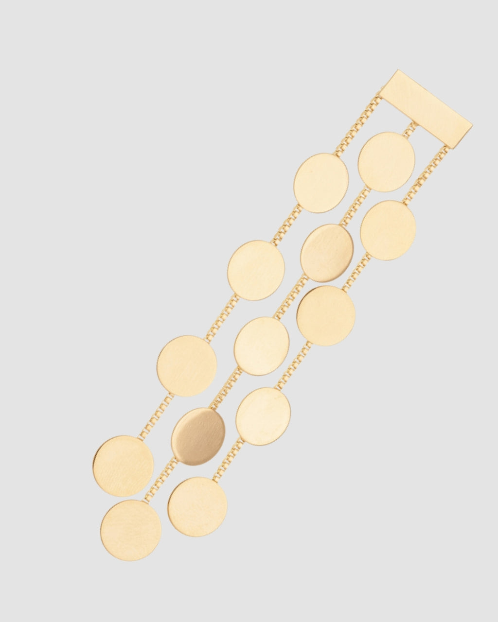 brinco dourado Papoula com design em cascata, corrente fina com discos circulares, 8 cm de comprimento e 1,5 cm de largura, semijoia com acabamento polido, fotografado em fundo cinza neutro