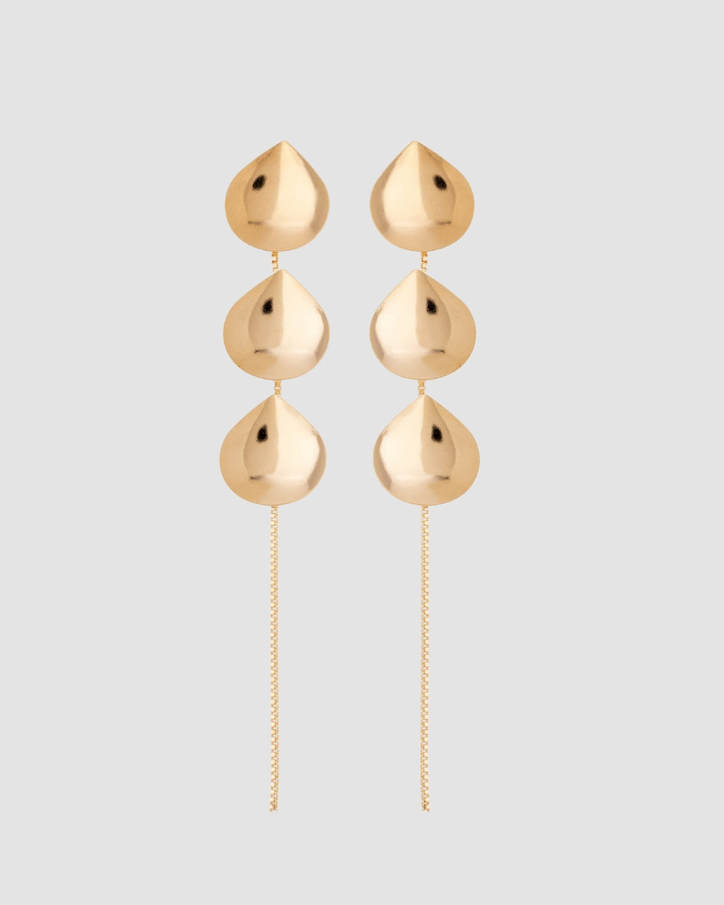 brinco gotas dourado Papoula, semijoia banhada a ouro 18k com 3 gotas de 1,5cm em corrente delicada, 10cm de comprimento total, acabamento polido brilhante, antialérgico para orelha furada, fotografado em fundo cinza neutro