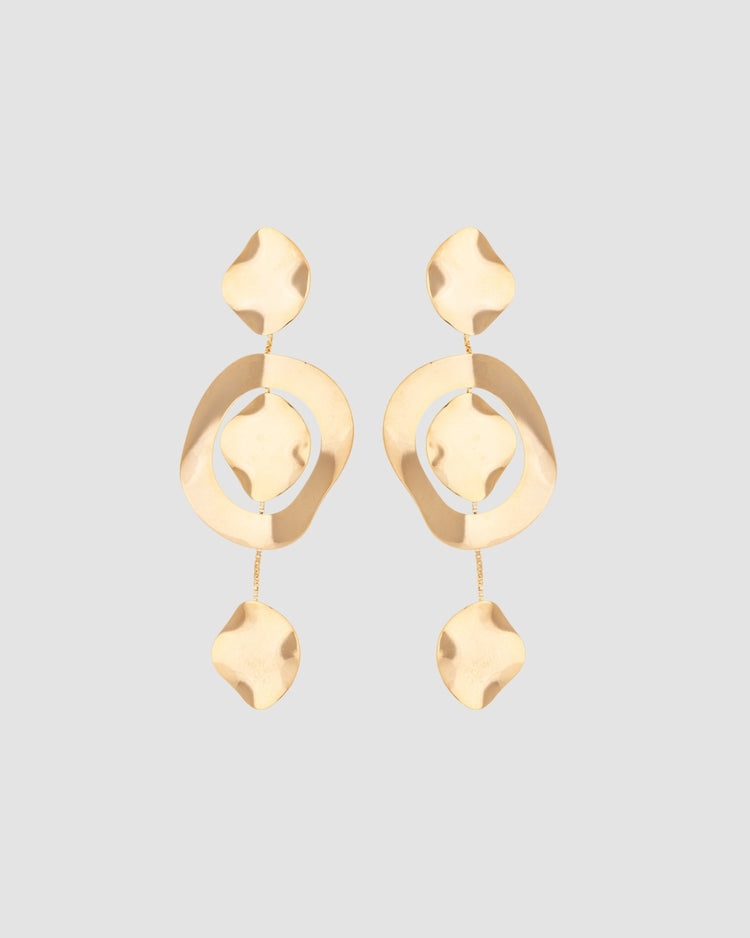 brinco movimento dourado Papoula com design em cascata, elementos orgânicos suspensos por correntes delicadas, 8,5 cm de comprimento e 3,5 cm de largura, semijoia com acabamento polido, fotografado em fundo cinza neutro