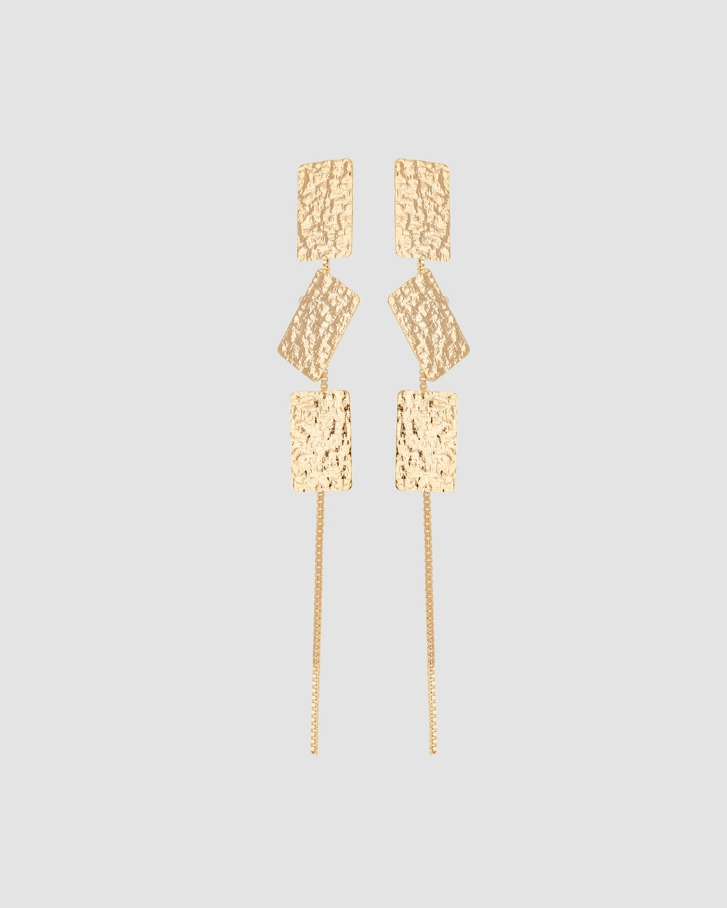 brinco comprido martelado dourado Papoula, semijoia banhada a ouro 18k com 3 peças marteladas, 9cm de comprimento, corrente fina delicada, acabamento polido brilhante, antialérgico para orelha furada, fotografado em fundo cinza neutro