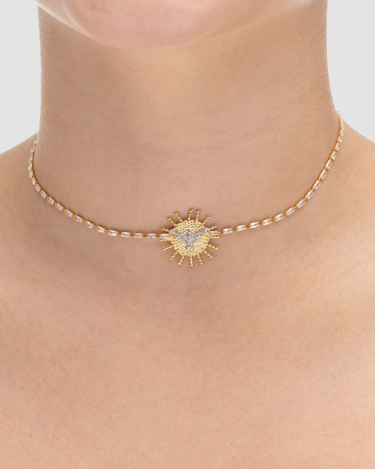 choker espírito santo dourada Papoula sendo usada por modelo, semijoia banhada a ouro 18k com corrente em zircônias retangulares e pingente espírito santo de 2cm, 30cm + 10cm de extensão, modelo com pele clara luminosa, fotografia de produto para e-commerce