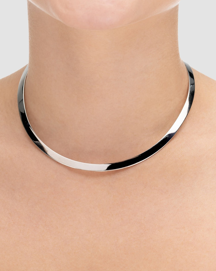 choker de aro duro prateado Papoula, semijoia com encaixe perfeito no colo, aro fino de 0,5 cm de espessura e acabamento polido, fotografado no pescoço