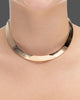 choker de aro duro dourado Papoula, semijoia com banda grossa de 1cm de espessura e encaixe perfeito no colo, acabamento polido, fotografado no pescoço