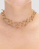 choker bolinhas dourada Papoula sendo usada por modelo, semijoia banhada a ouro 18k com design em bolinhas delicadas, 30cm + 15cm de ajuste, modelo com pele clara, blusa texturizada minimalista, estilo editorial premium, maquiagem natural elegante, fundo neutro cinza, fotografia de produto para e-commerce