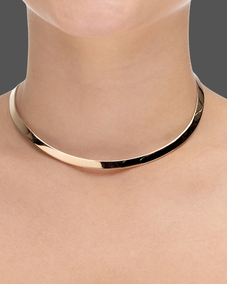 choker de aro duro dourado Papoula, semijoia com encaixe perfeito no colo, aro fino de 0,5 cm de espessura e acabamento polido, fotografado no pescoço