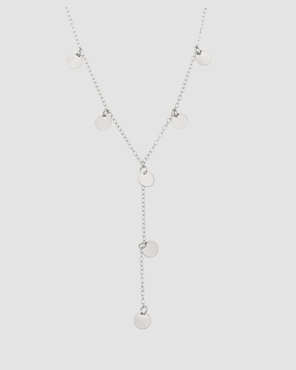 colar choker prateado Papoula em formato Y, semijoia com corrente fina e mini pingentes circulares, modelo de 35 cm fotografado em fundo cinza neutro
