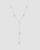 colar choker prateado Papoula em formato Y, semijoia com corrente fina e mini pingentes circulares, modelo de 35 cm fotografado em fundo cinza neutro