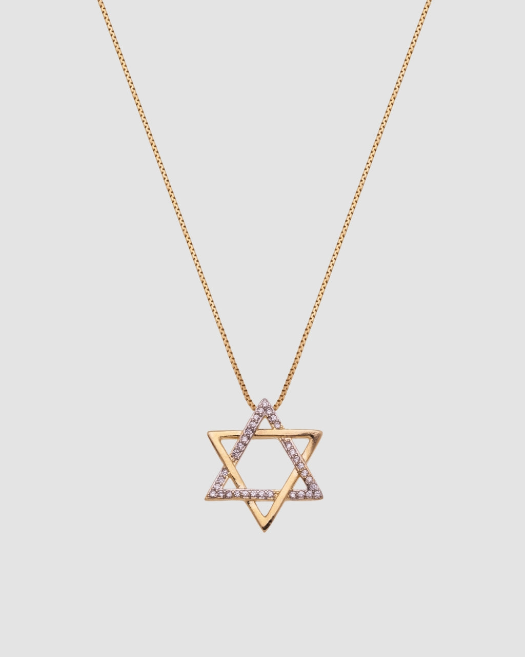 colar estrela de davi dourado Papoula, semijoia banhada a ouro 18k com pendente estrela de 1,8cm em corrente veneziana de 45cm, zircônias brilhantes, acabamento polido brilhante, antialérgico, fotografado em fundo cinza neutro, fotografia de produto para e-commerce