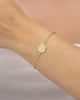 pulseira feminina banhada a ouro 18k com medalha São Bento frente no pulso — semijoia religiosa delicada Papoula