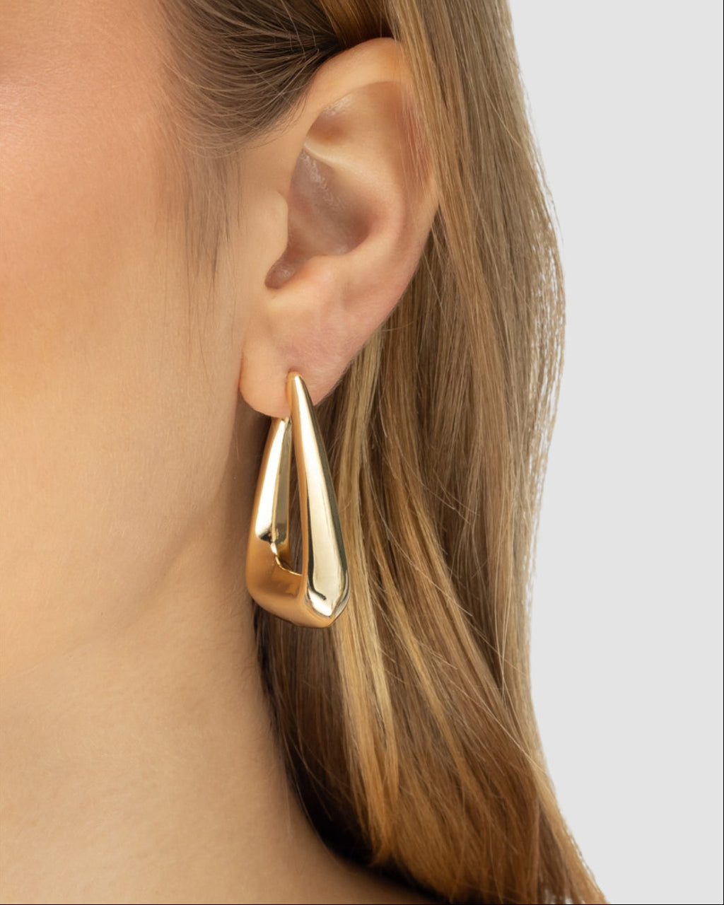 Modelo usando brinco argola gota volumétrico dourado leve semijoia banhado a ouro 18k — acessório feminino statement Papoula