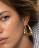 Modelo usando brinco argola gota dourado volumétrico semijoia banhado a ouro 18k — acessório feminino Papoula