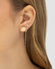 Modelo A usando brinco ear thread fio placa redonda dourado semijoia banhado a ouro enrolado na orelha — acessório feminino Papoula