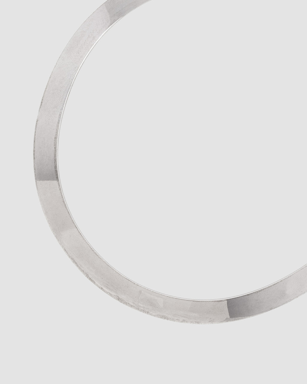 choker de aro duro prateado Papoula, semijoia com banda grossa de 1cm de espessura e encaixe perfeito no colo, acabamento polido, fotografado em fundo cinza neutro
