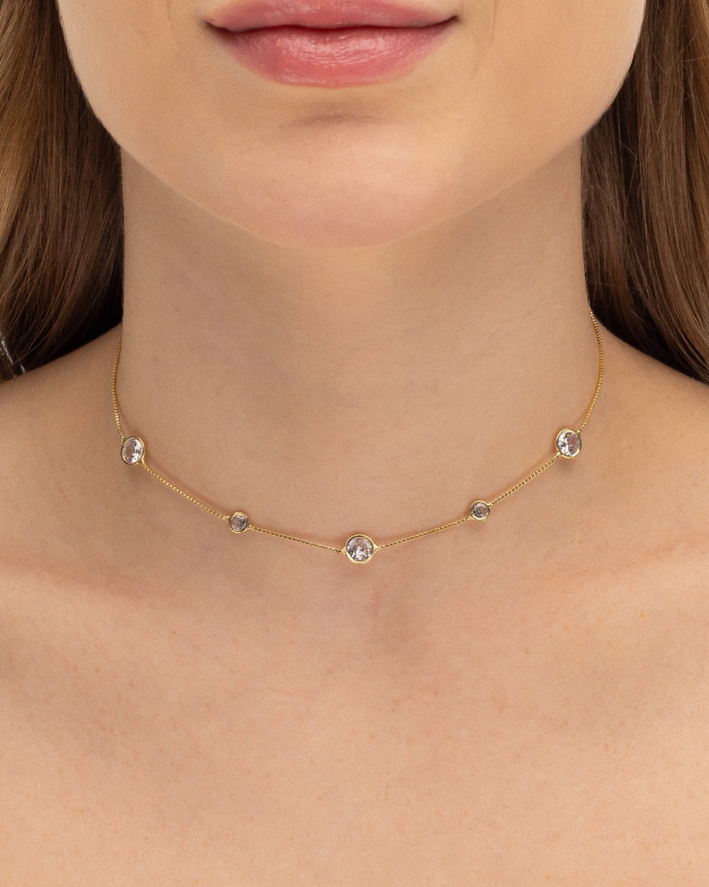 Modelo usando colar choker com zircônias cravejadas banhado a ouro no pescoço — acessório feminino Papoula