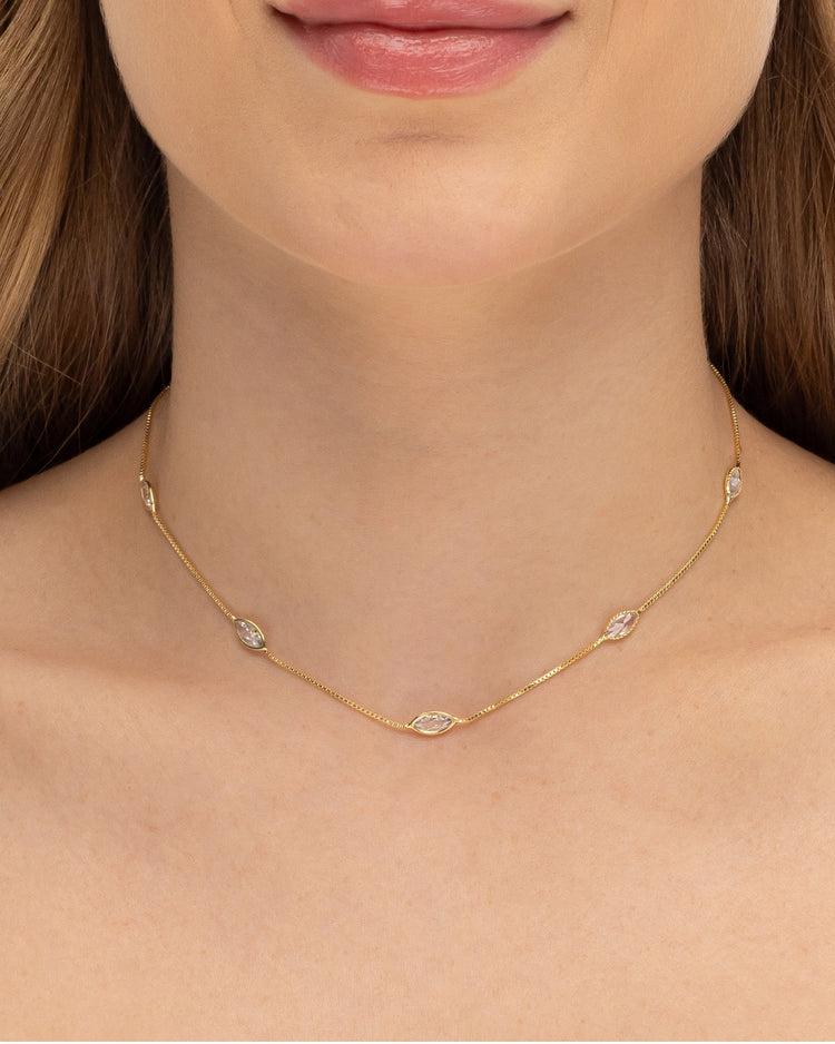Modelo usando colar corrente com zircônias navete banhado a ouro no decote — acessório feminino Papoula