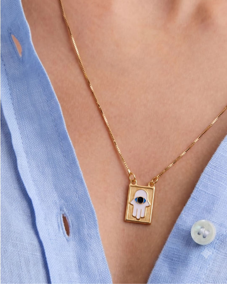 Modelo usando colar com pingente placa hamsa e olho grego esmaltado dourado semijoia banhado a ouro — acessório feminino Papoula