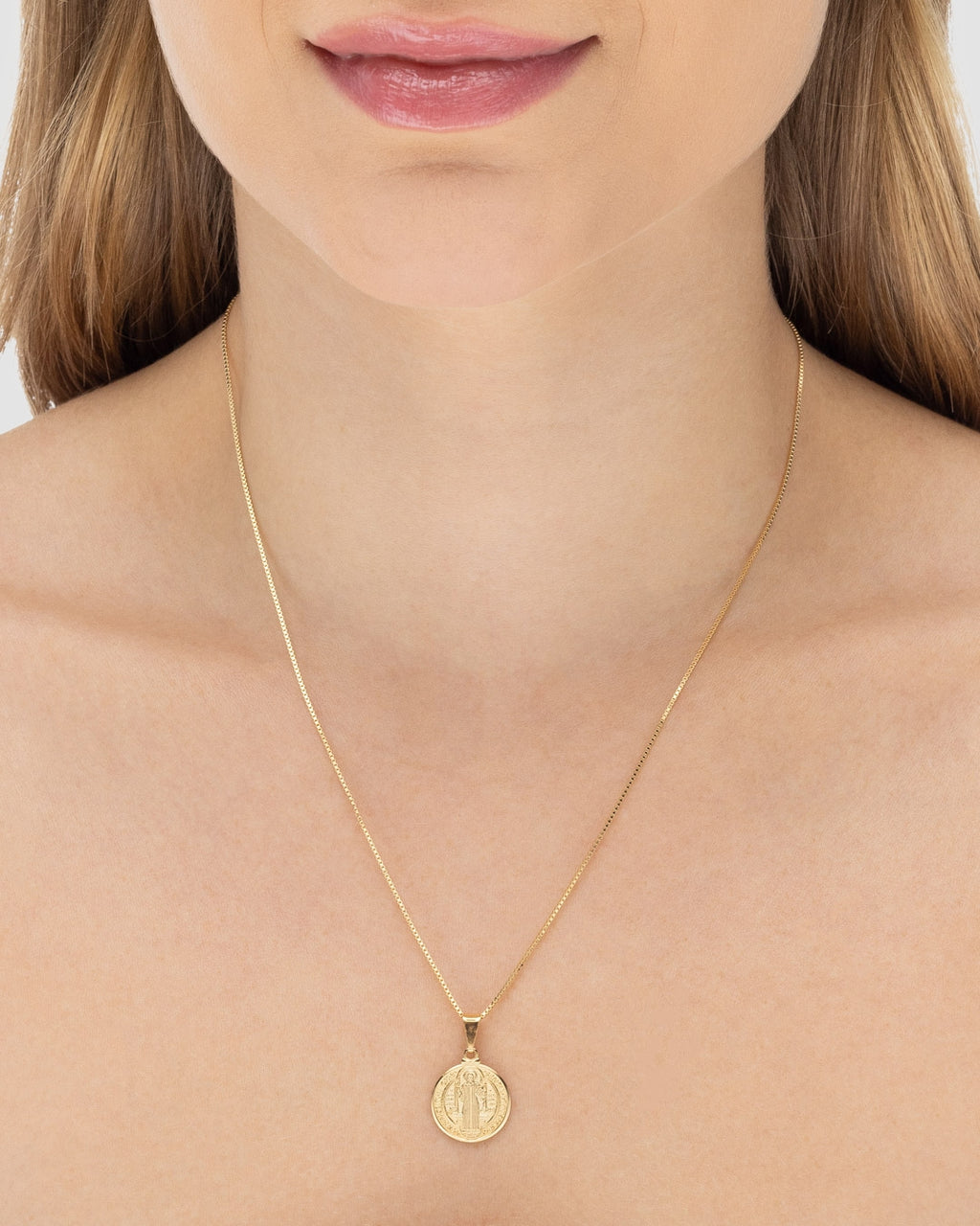 Modelo usando colar medalha São Bento banhado a ouro 18k com corrente veneziana — semijoia religiosa feminina Papoula
