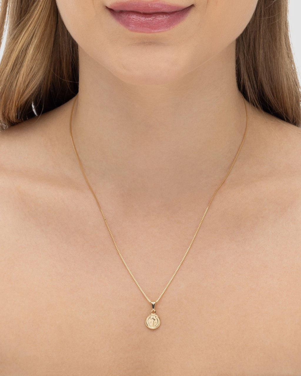 Modelo usando colar medalha São Bento dourado pequeno delicado com corrente veneziana — semijoia religiosa Papoula
