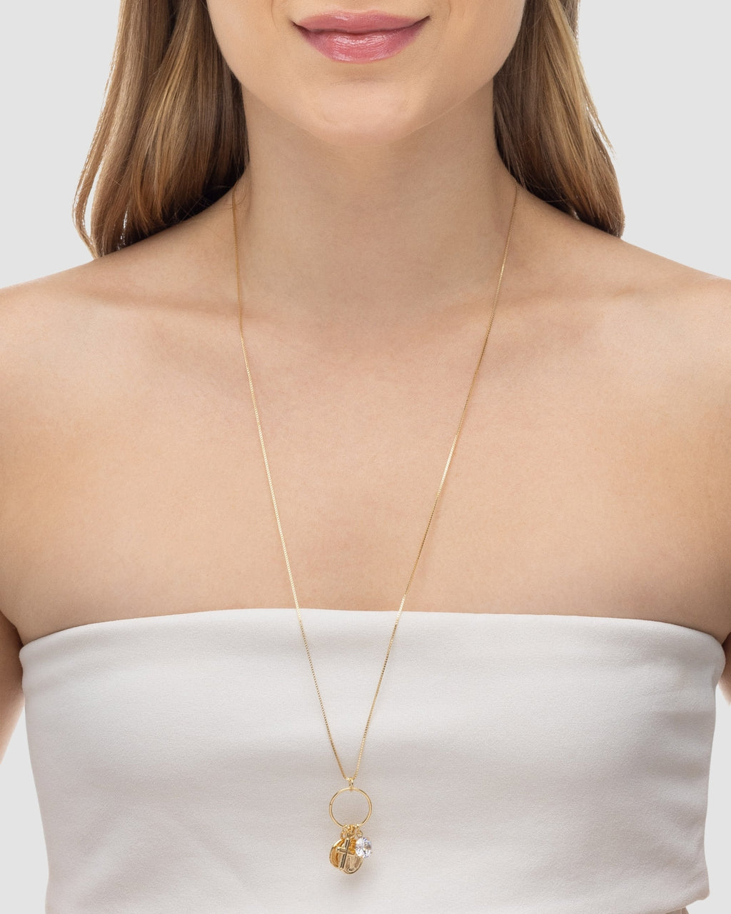 Modelo usando colar patuá longo banhado a ouro 18k com medalhas religiosas crucifixo e strass — semijoia feminina Papoula