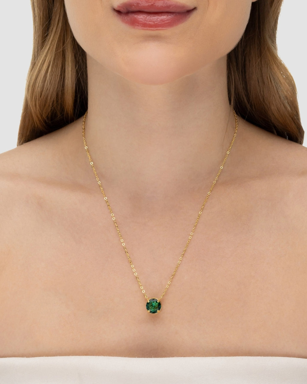 Modelo usando colar ponto de luz zircônia esmeralda banhado a ouro no decote — acessório feminino Papoula