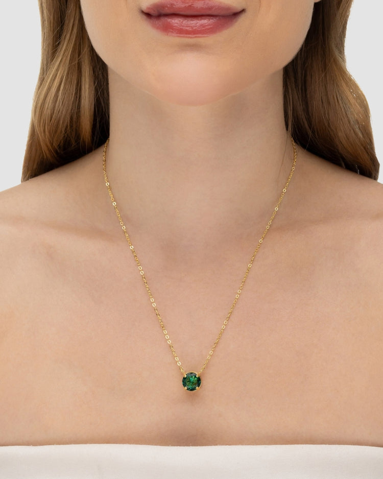 Modelo usando colar ponto de luz zircônia esmeralda banhado a ouro no decote — acessório feminino Papoula