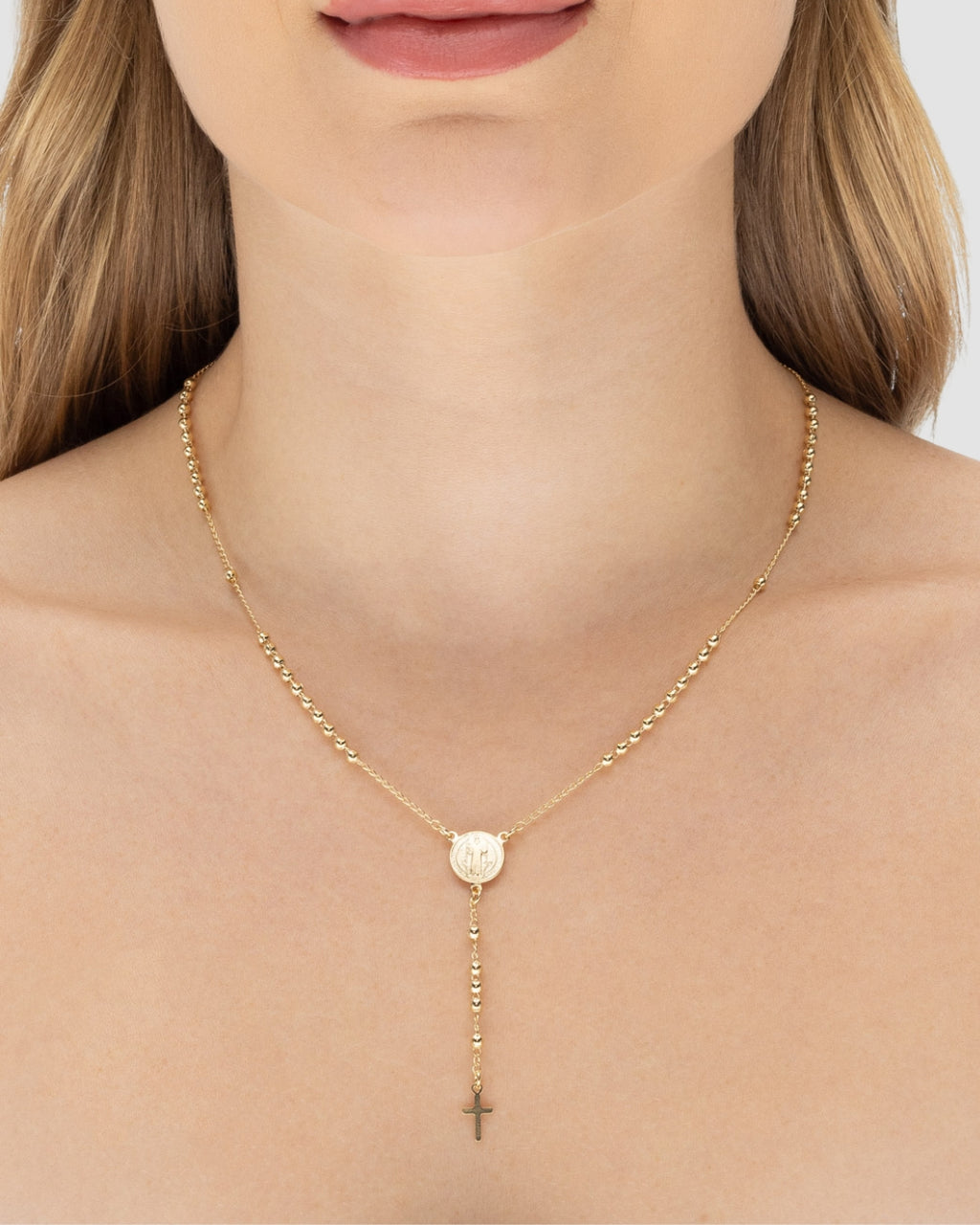 Modelo usando colar Y terço São Bento semijoia banhada a ouro 18k com medalha e crucifixo — semijoia religiosa feminina Papoula