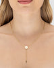 Modelo usando colar Y terço São Bento semijoia banhada a ouro 18k com medalha e crucifixo — semijoia religiosa feminina Papoula
