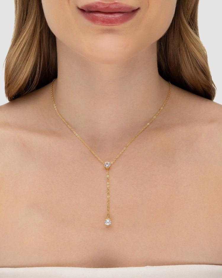 Modelo usando colar Y com zircônia incolor banhado a ouro no decote — acessório feminino Papoula