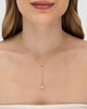 Modelo usando colar Y com zircônia incolor banhado a ouro no decote — acessório feminino Papoula
