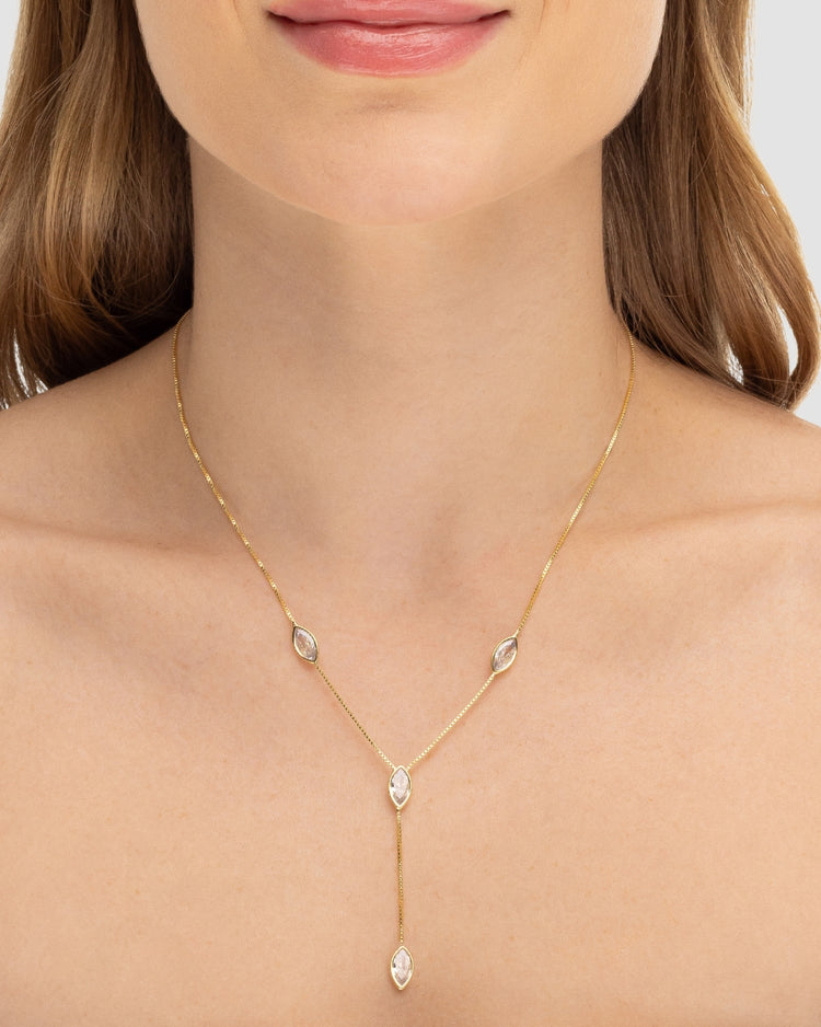 Modelo usando colar Y com zircônias navete banhado a ouro no decote — acessório feminino Papoula