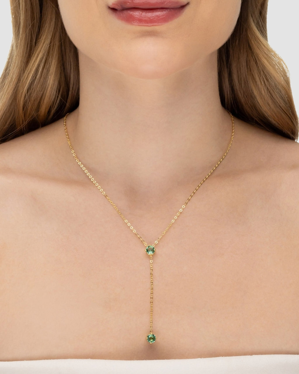 Modelo usando colar Y com zircônia peridoto banhado a ouro no decote — acessório feminino Papoula