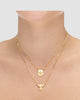 colar anjinho duplo dourado Papoula, semijoia banhada a ouro 18k com duas correntes em camadas, anjinho estilizado zirconia 40cm + 10cm extensão e anjinho minimalista 42cm, acabamento polido, fotografado no pescoço