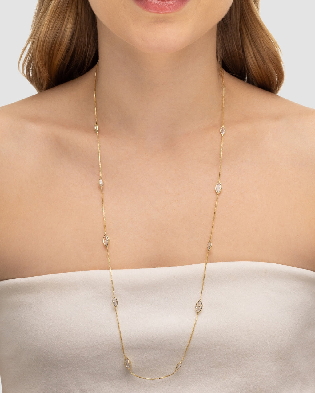 Modelo usando colar longo com zircônias navete banhado a ouro no decote — acessório feminino Papoula