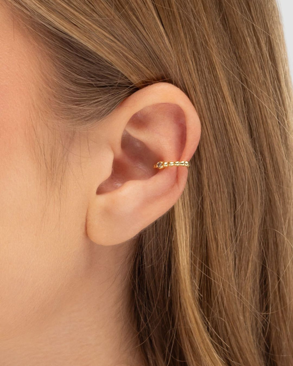 Modelo usando piercing fake bolinhas com zircônia banhado a ouro sem necessidade de furo — acessório feminino Papoula