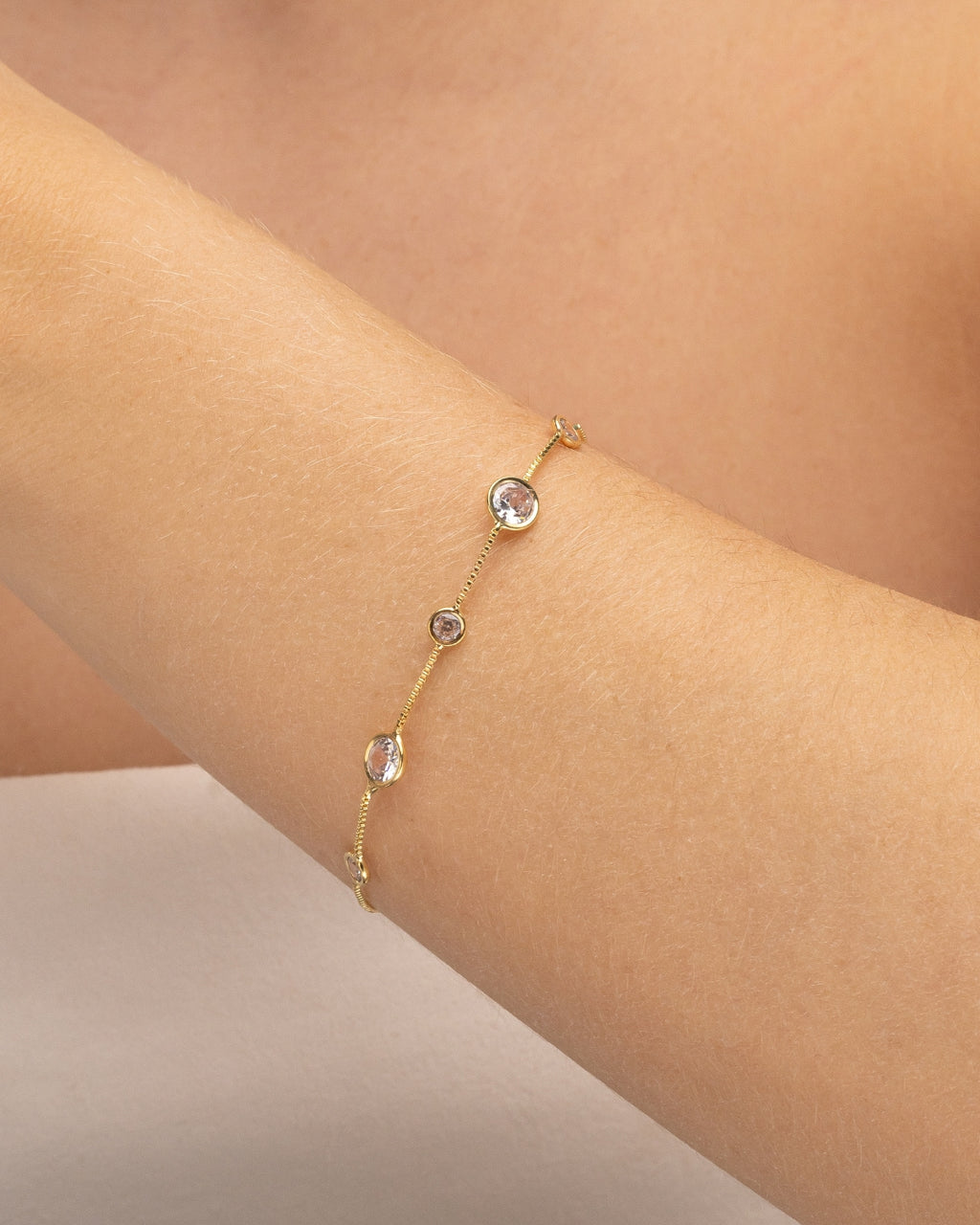 Modelo usando pulseira corrente com zircônias cravejadas banhado a ouro no pulso — acessório feminino Papoula