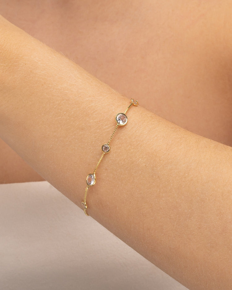Modelo usando pulseira corrente com zircônias cravejadas banhado a ouro no pulso — acessório feminino Papoula