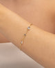Modelo usando pulseira corrente com zircônias cravejadas banhado a ouro no pulso — acessório feminino Papoula